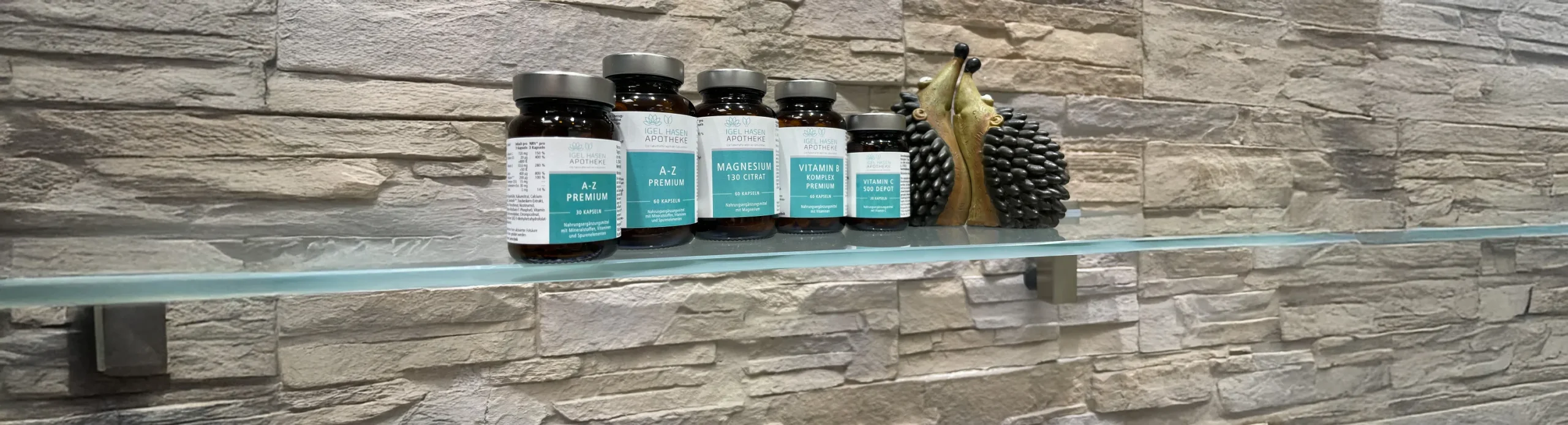 Nahrungsergänzungsmittel der Igel Hasen Apotheke auf Glasregal vor Steinwand